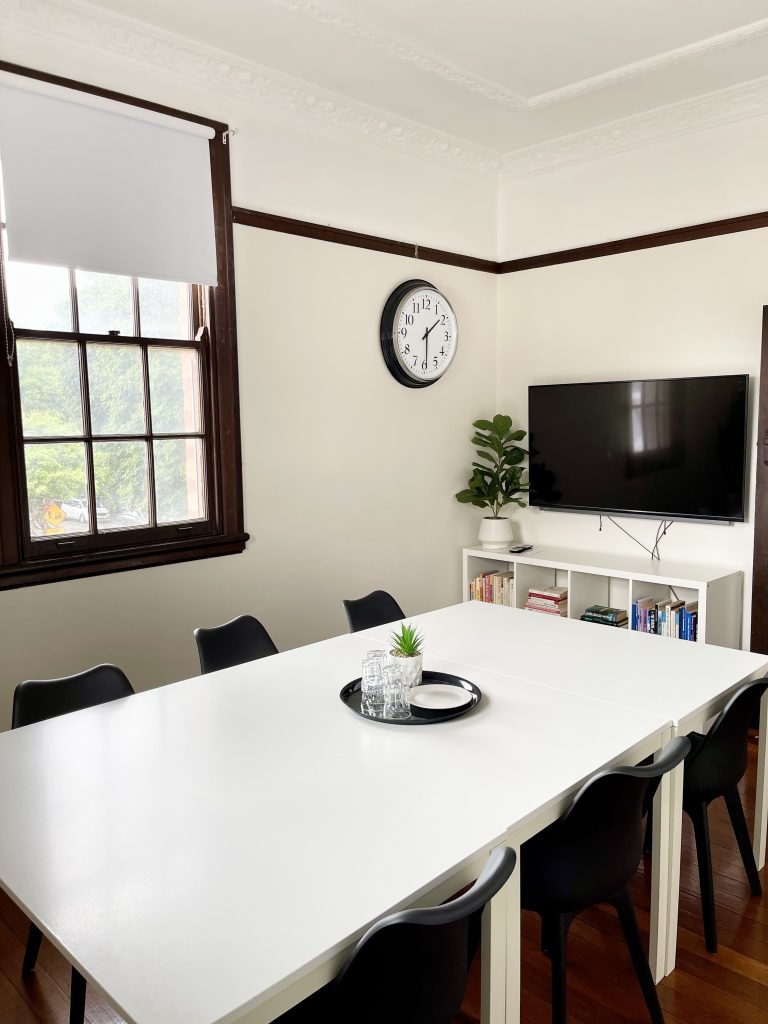 Small professional meeting room with desk chairs and video conferencing setup